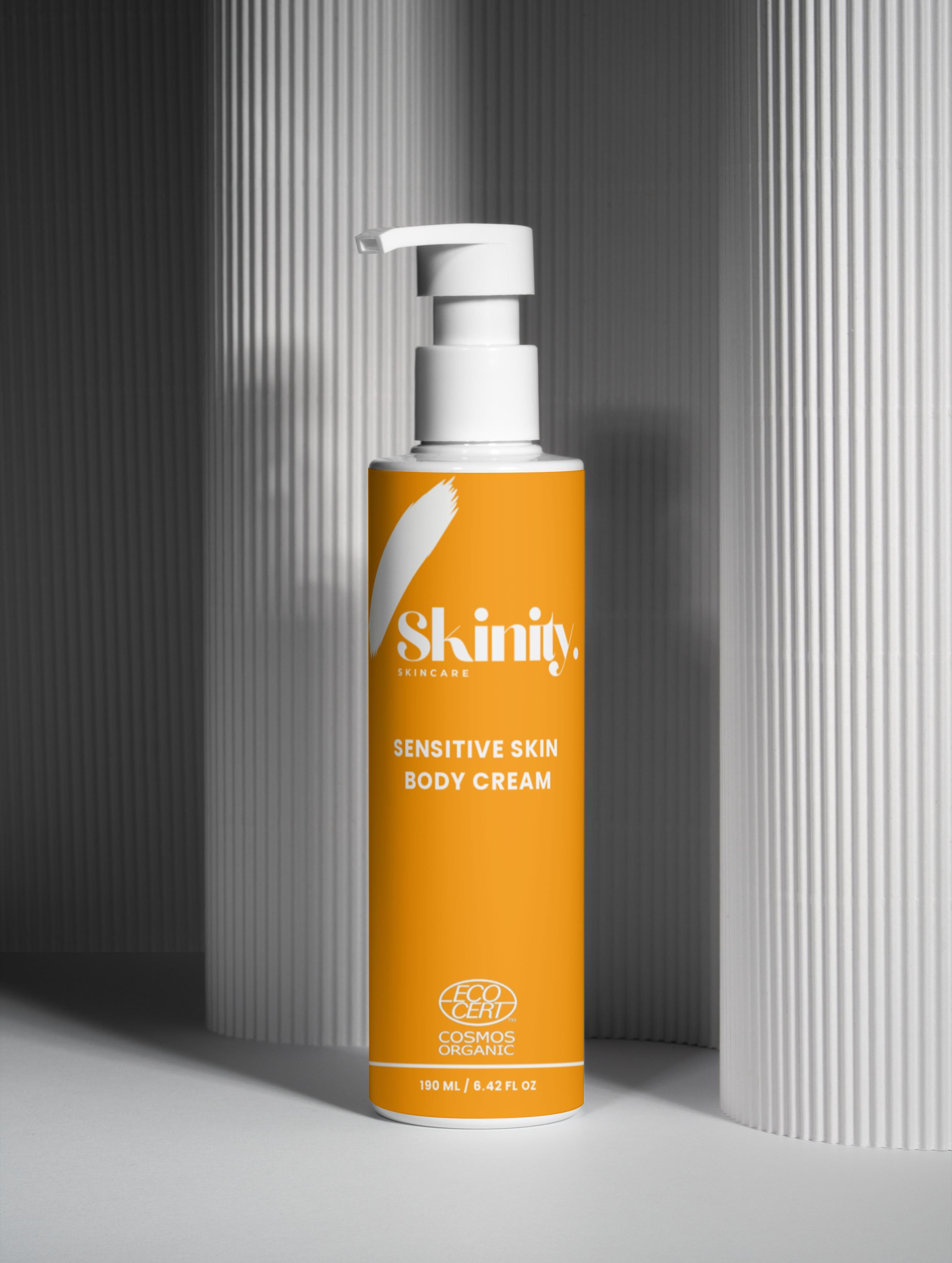 Sensitive Skin Body Cream Vegan in a sleek bottle with a pump, set against a minimalist background.