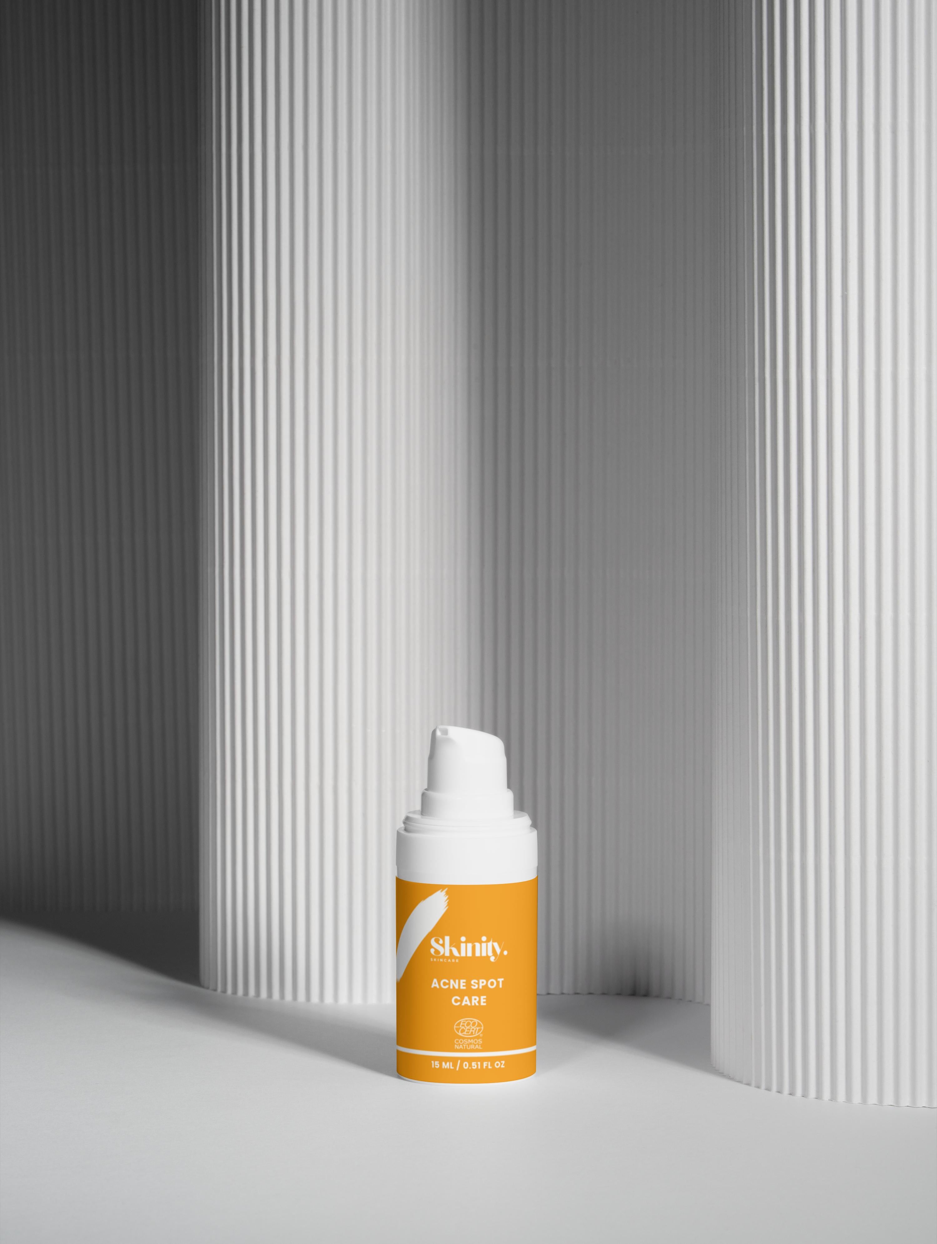Acne Spot Care Serum For All Skin Types in a sleek bottle against a minimalist background.