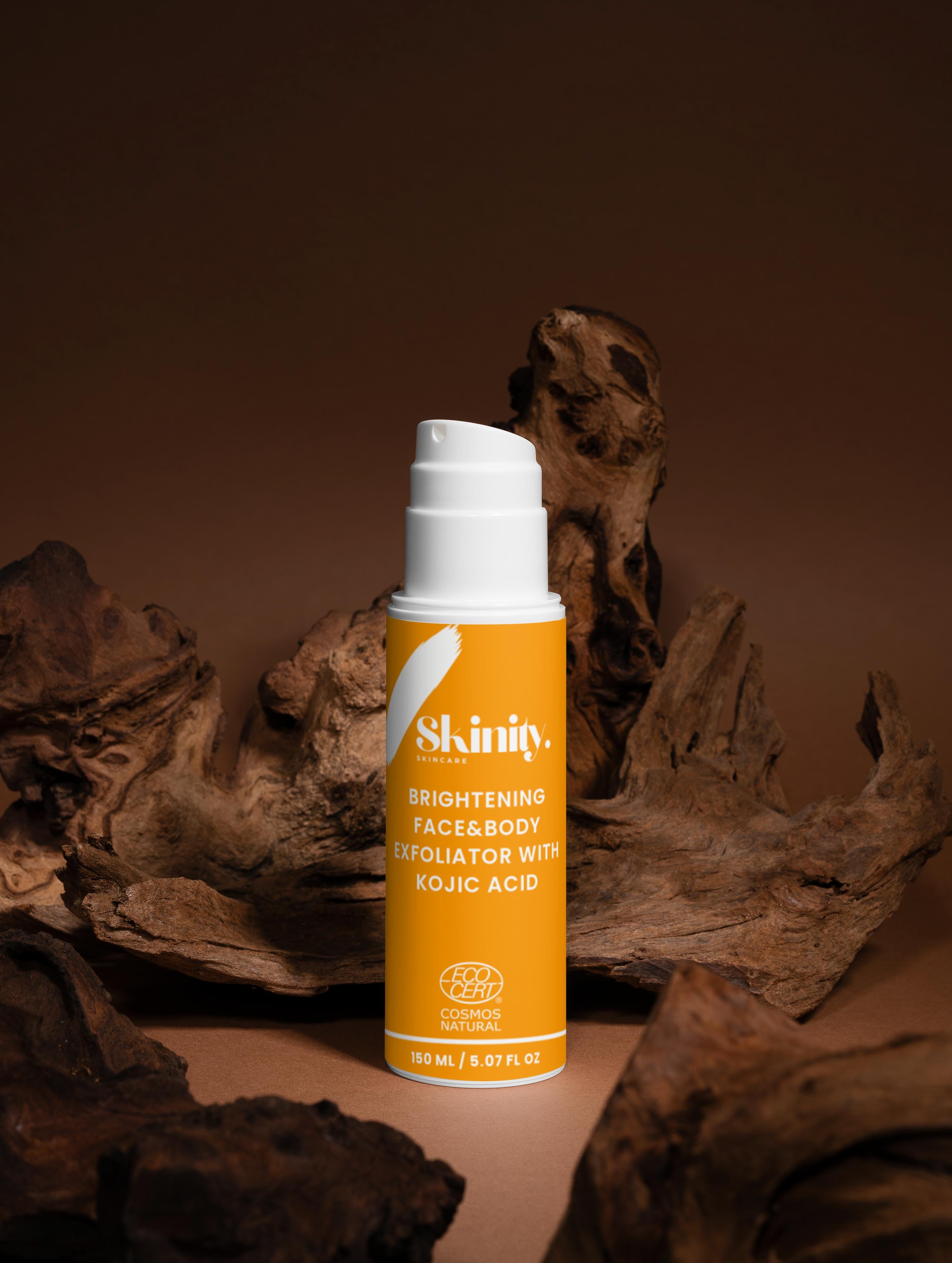 Brightening Face and Body Exfoliator with Kojic Acid bottle on textured background