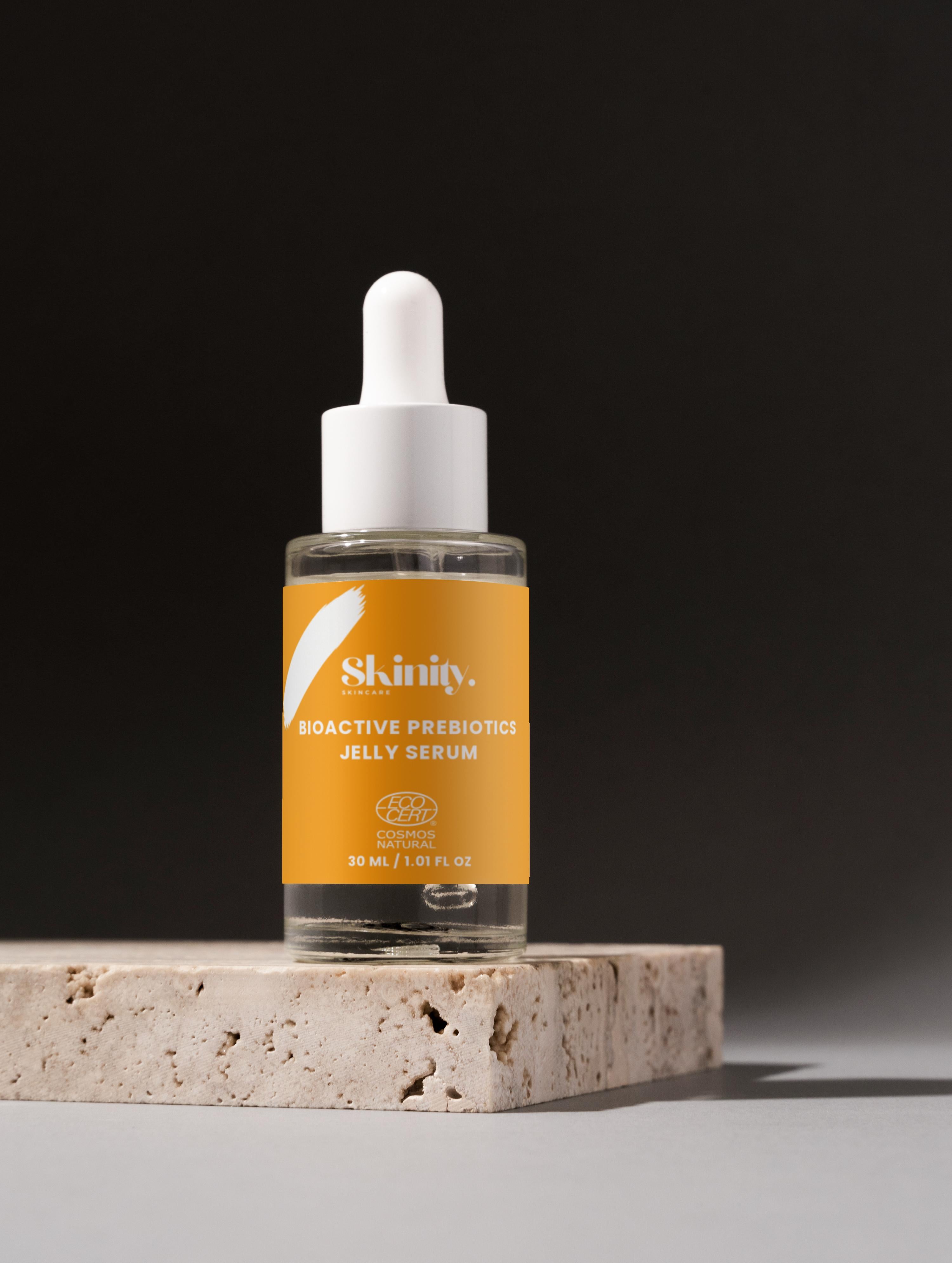 Skinity Bioactive Prebiotics Jelly Serum bottle on a stone pedestal with a dark background.