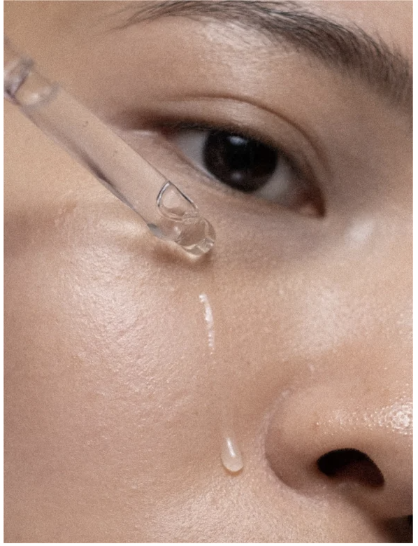 Close-up of a model applying Bioactive Prebiotics Jelly Serum for healthy, hydrated skin.