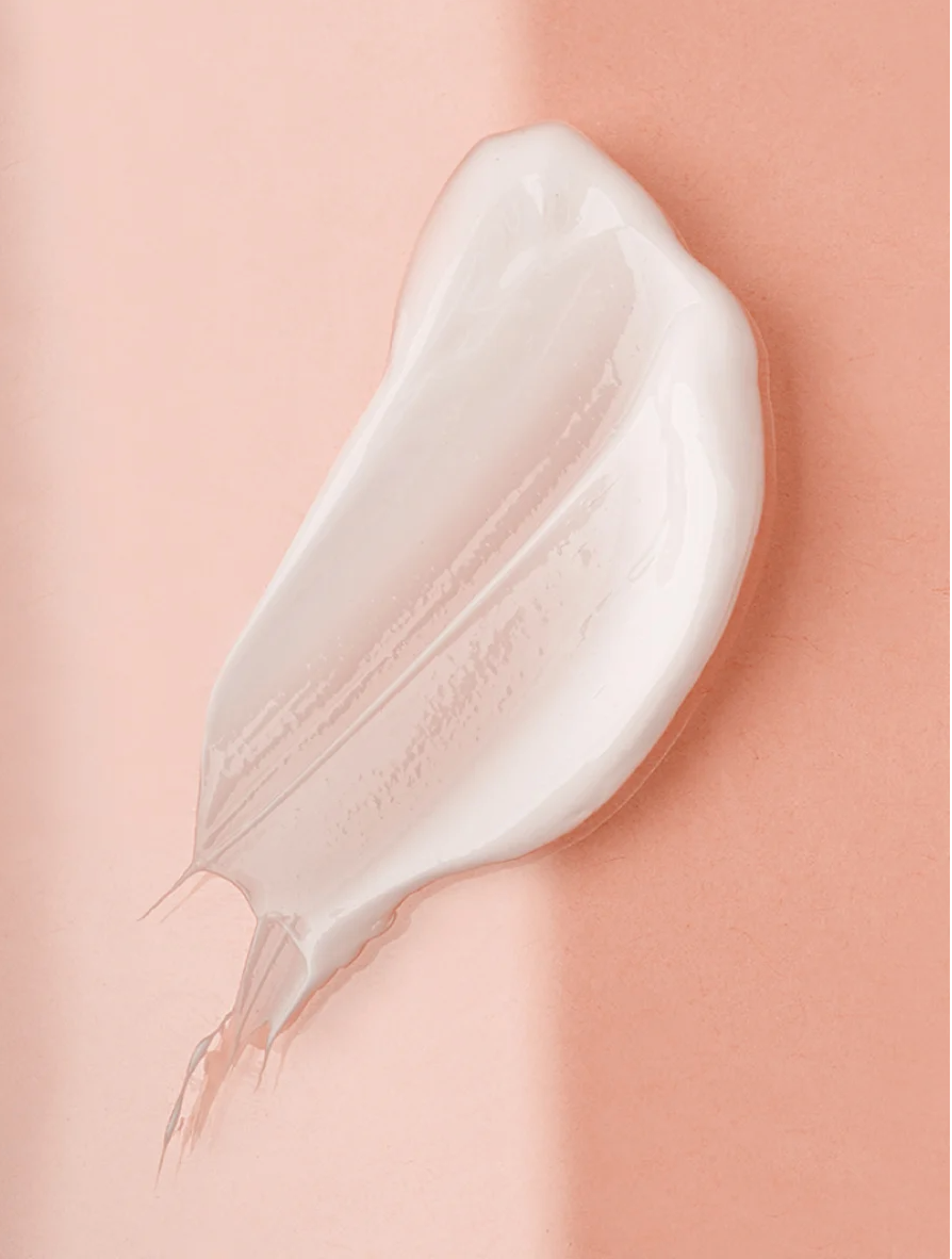 Youthful Glow Serum For All Skin Types creamy texture on a soft pastel background.