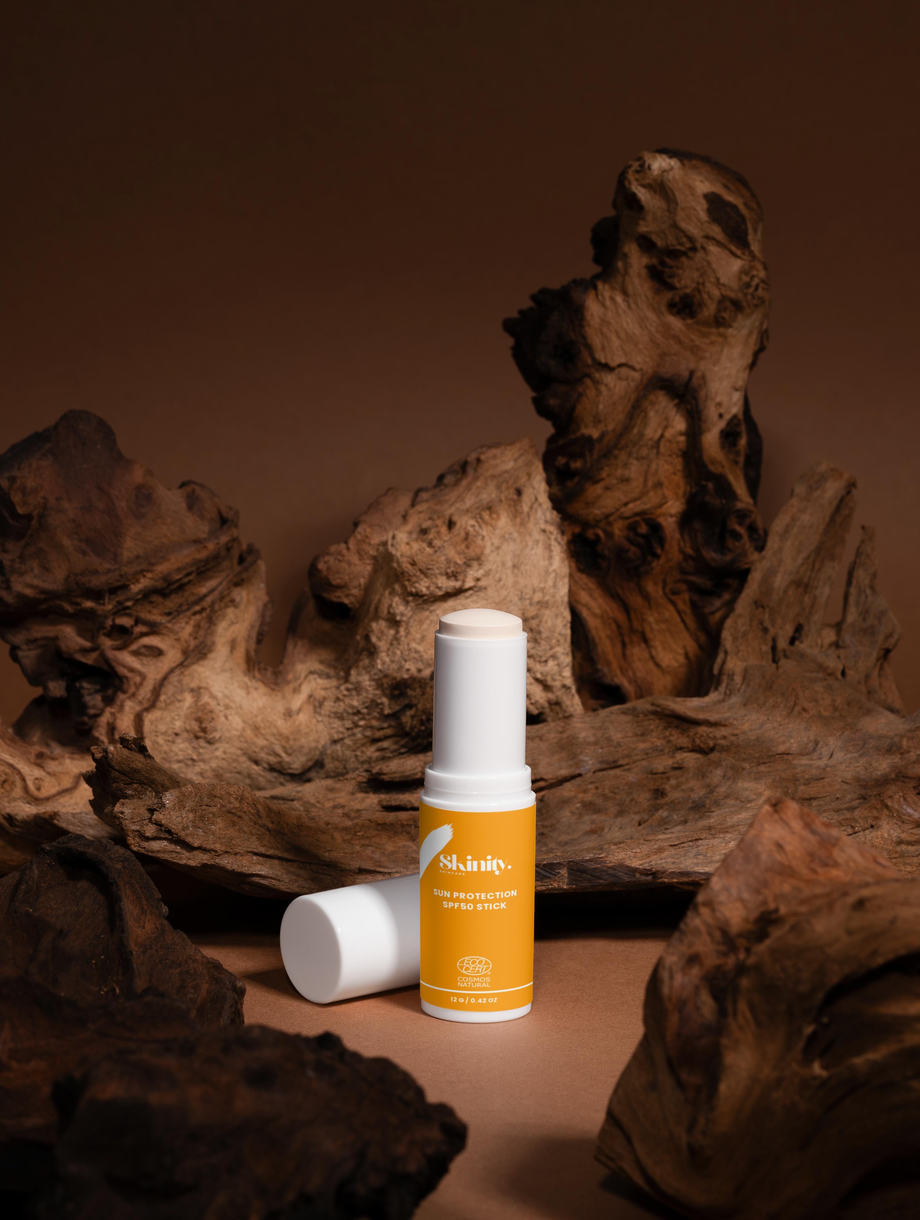 Sun Protection SPF50 Stick no tint displayed in a natural setting with wooden textures.