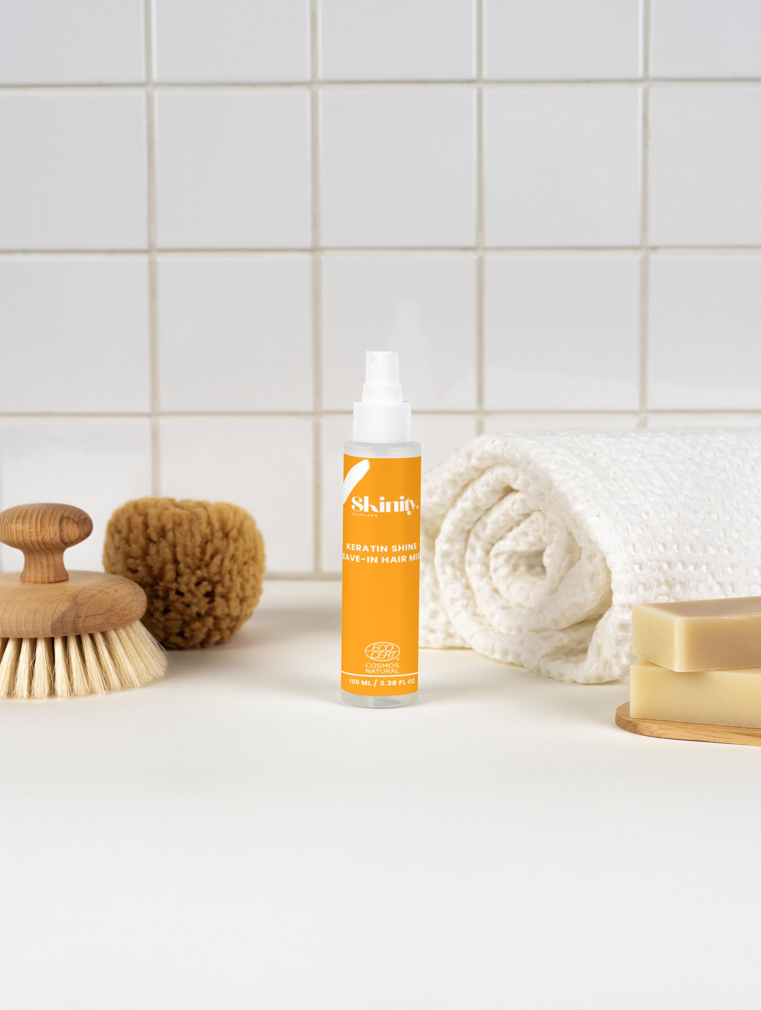 Keratin Shine Leave In Hair Mist bottle with natural hair care accessories on a clean, light background.