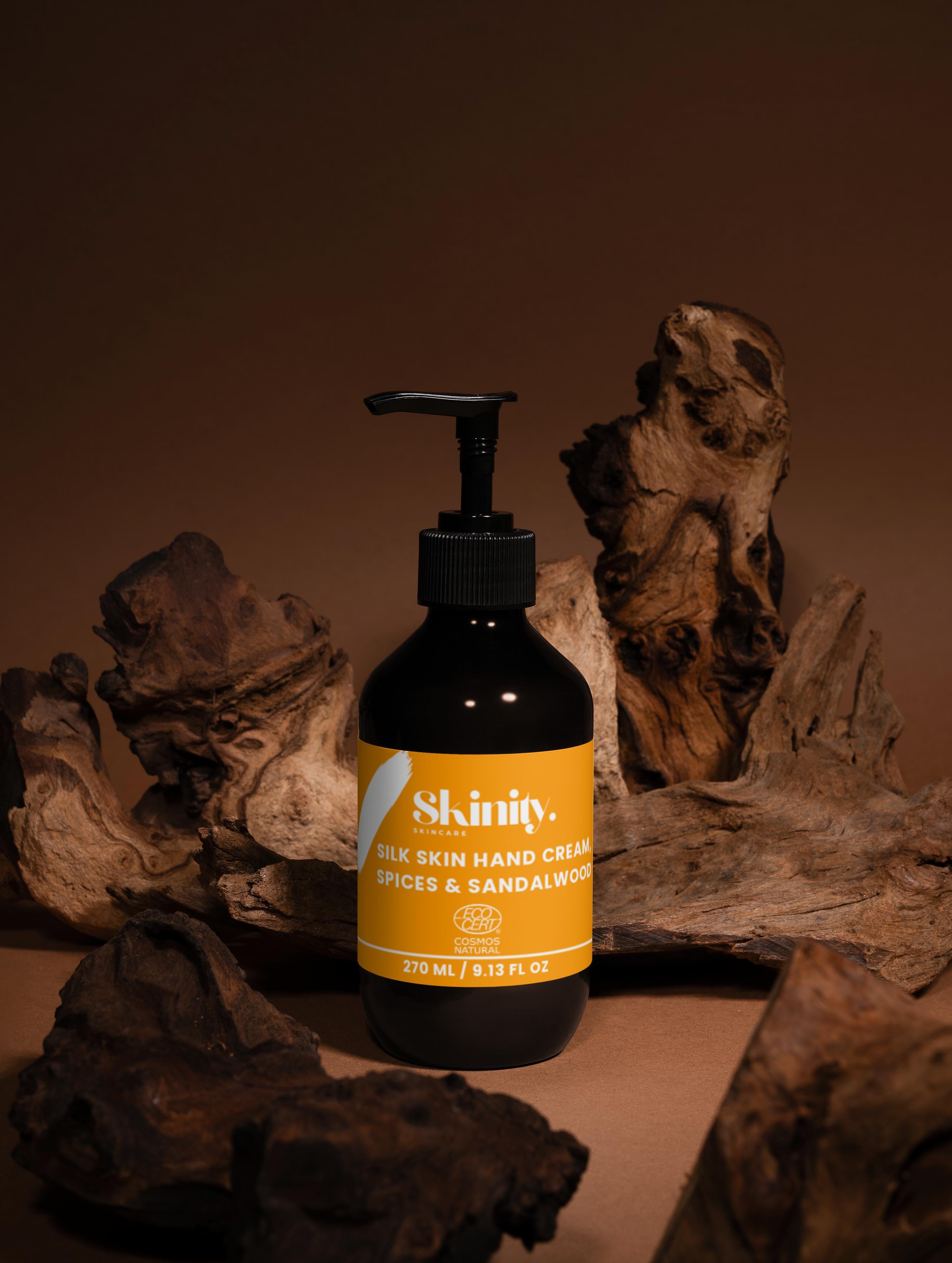 Silk Skin Hand Cream Spices and Sandalwood bottle on natural wood background for hydration and softness.