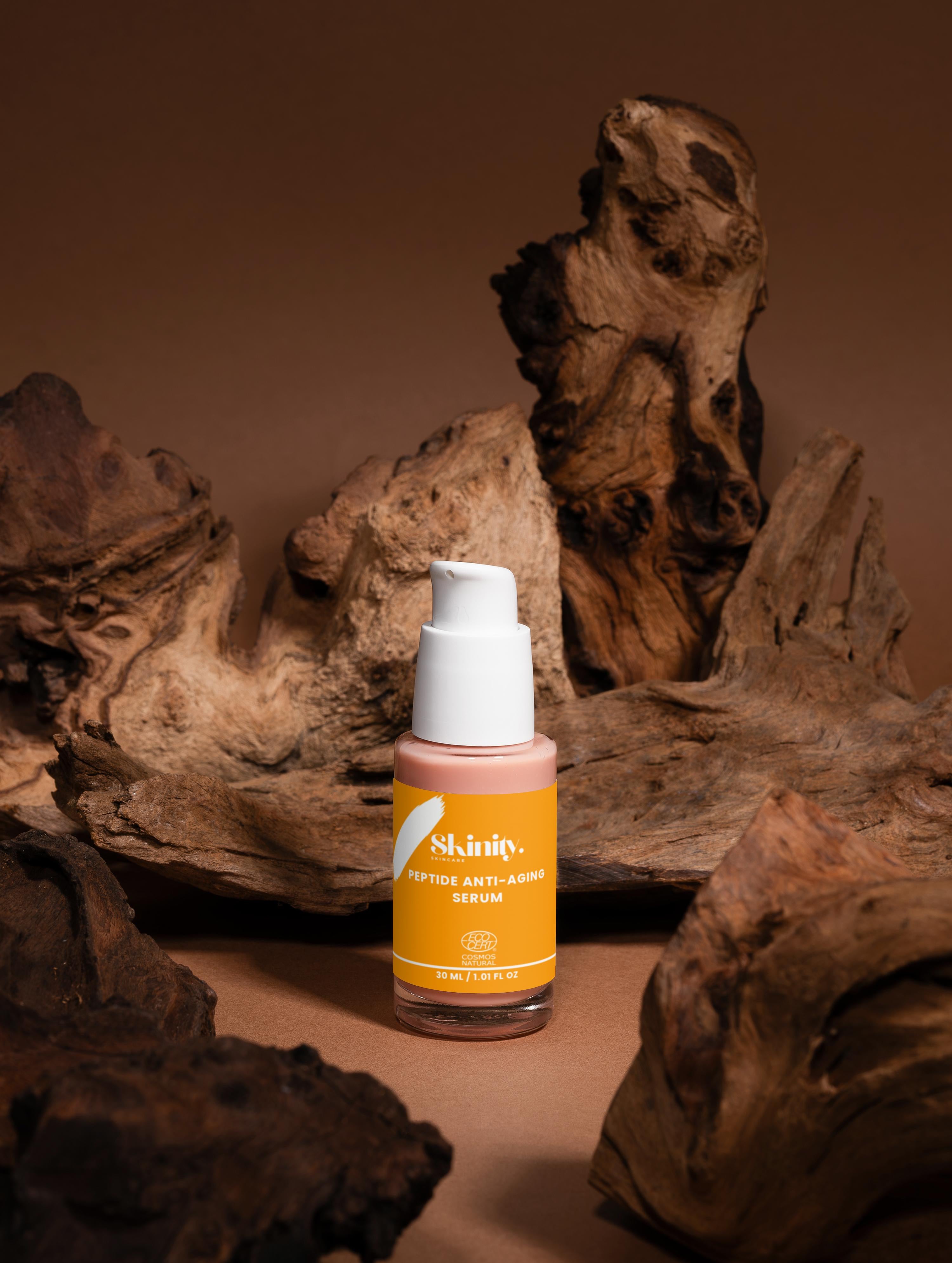 Peptide Anti-Aging Serum for All skin displayed in an artistic arrangement with wood background.