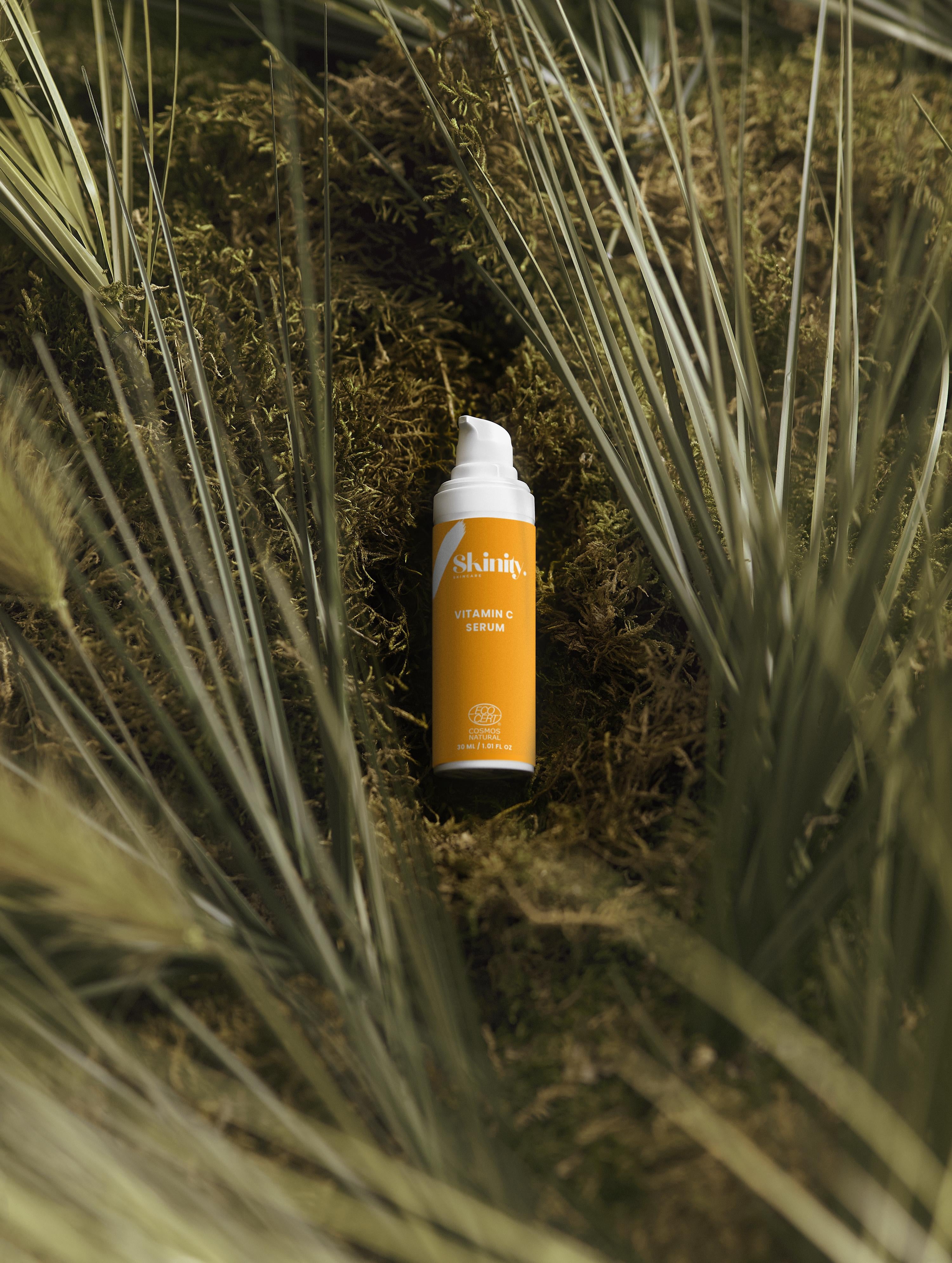 Vitamin C serum for all skin types displayed among lush greenery and natural elements.