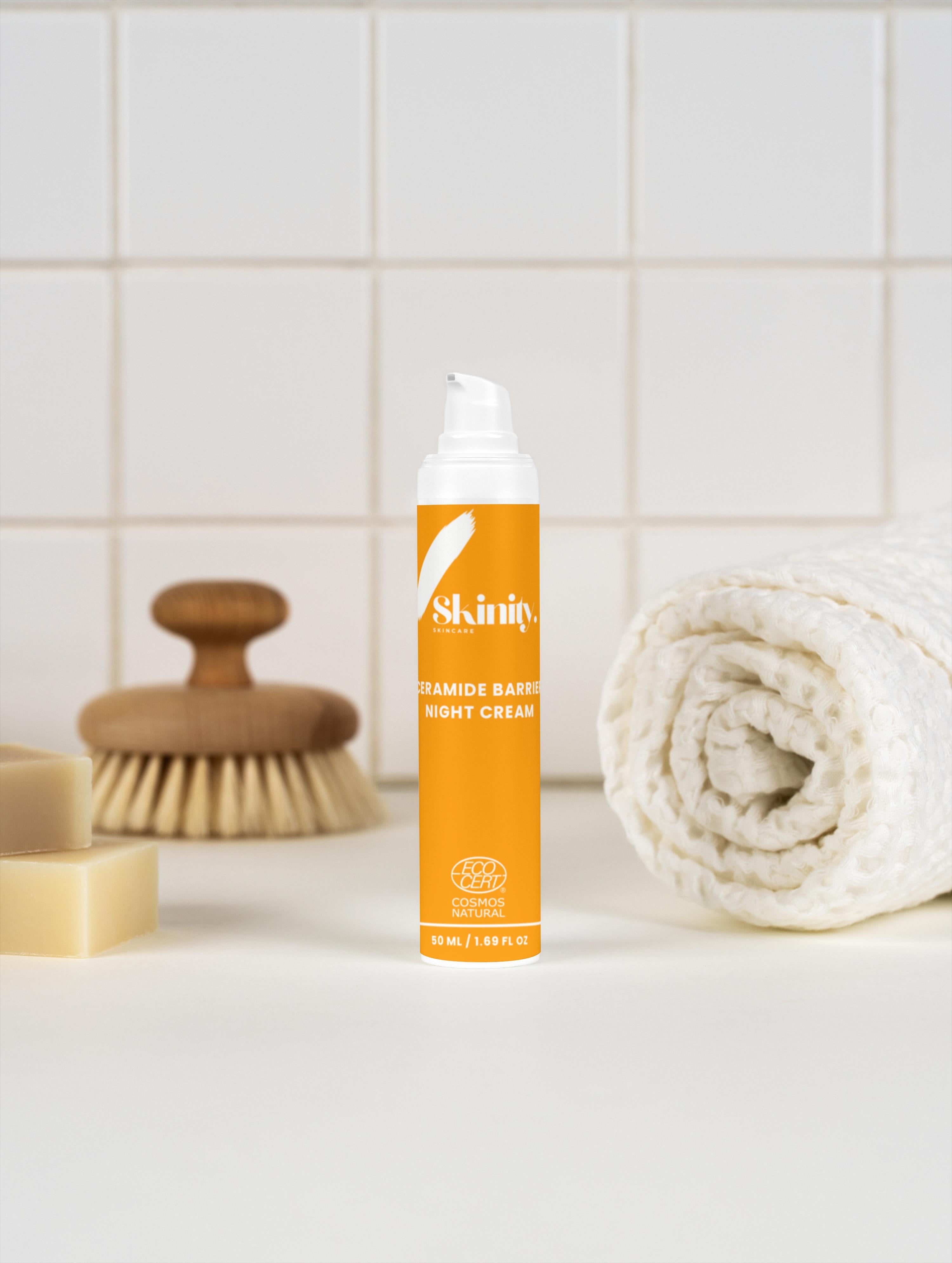 Ceramide Barrier Night Cream for all Skin Types in a modern bathroom setting with a towel and a brush.